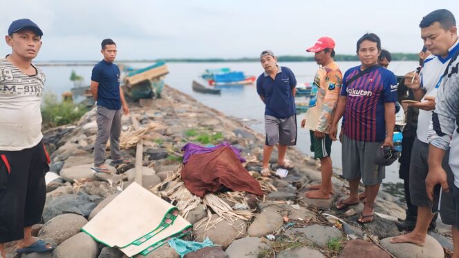 
					TEWAS: Warga dan petugas berada di dekat jenazah korban usai dievakuasi dari tengah laut. (foto: Hafiz Rozani).