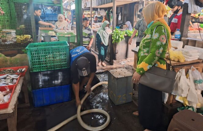 
					MENGGANGU: Petugas Disperindag Kab. Pasuruan saat mengecek dampak banjir di Pasar Bangil. (foto: Moh. Rois)