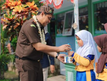 BERBAGI: Kejari Kabupaten Probolinggo, Ahmad Nuril Alam, saat memberikan MBG ke siswi SDN 1 Sebaung. (foto: Ali Ya'lu).