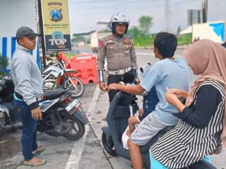 DILARANG: Petugas kepolisian memberikan imbauan ke pengguna sepeda listrik yang berkendara di jalan raya. (foto: Ali Ya'lu).