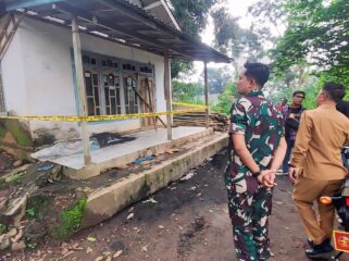 BRUTAL: Anggota Koramil dan Camat Lumbang saat berada di depan rumah korban pasca perampokan brutal yang dialami korban. (foto: Hafiz Rozani)
