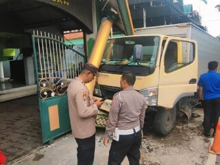 Polisi meninjau mobil boks yang menabrak gapura masjid di Kota Pasuruan.