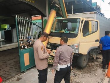 Polisi meninjau mobil boks yang menabrak gapura masjid di Kota Pasuruan.