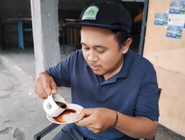 Seorang warga sedang menikmati secangkir kopi khas Senduro.