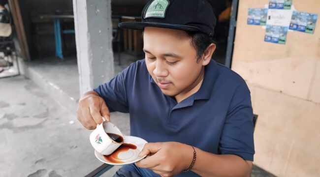 Seorang warga sedang menikmati secangkir kopi khas Senduro.