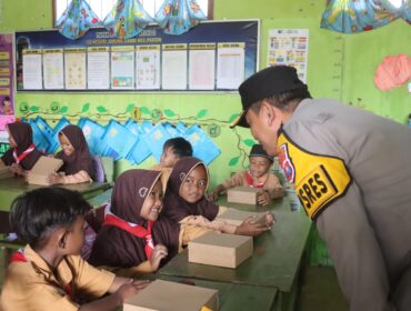 BERBAGI: Kapolres Probolinggo, AKBP Wisnu Wardana, saat membagikan makanan bergizi ke siswa SDN Jabung Candi. (foto: Istimewa)
