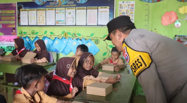 BERBAGI: Kapolres Probolinggo, AKBP Wisnu Wardana, saat membagikan makanan bergizi ke siswa SDN Jabung Candi. (foto: Istimewa)
