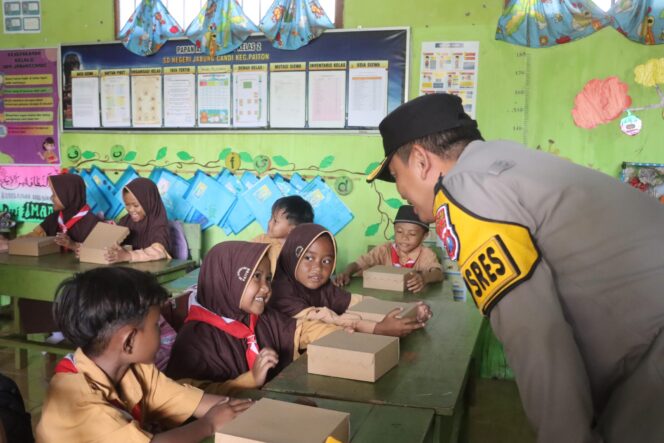 
					BERBAGI: Kapolres Probolinggo, AKBP Wisnu Wardana, saat membagikan makanan bergizi ke siswa SDN Jabung Candi. (foto: Istimewa)
