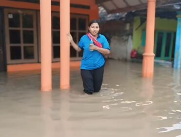 TERENDAM: Warga berada ditengah-tengah pemukiman yang terendam banjir di Kabupaten Pasuruan. (foto: Moh. Rois).
