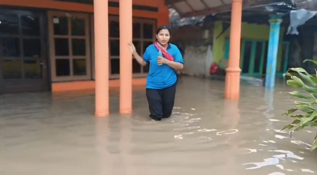 TERENDAM: Warga berada ditengah-tengah pemukiman yang terendam banjir di Kabupaten Pasuruan. (foto: Moh. Rois).
