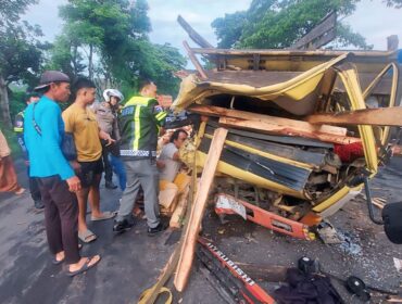 TERJEPIT: Polisi dibantu warga mengevakuasi sopir truk bermuatan kayu pasca terlibat kecelakaan di jalur pantura Desa Banjarsari, Kec. Sumberasih, Kab. Probolinggo. (foto: Hafiz Rozani).