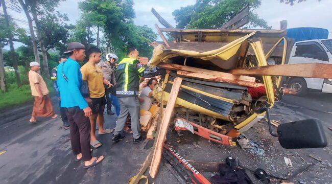 TERJEPIT: Polisi dibantu warga mengevakuasi sopir truk bermuatan kayu pasca terlibat kecelakaan di jalur pantura Desa Banjarsari, Kec. Sumberasih, Kab. Probolinggo. (foto: Hafiz Rozani).