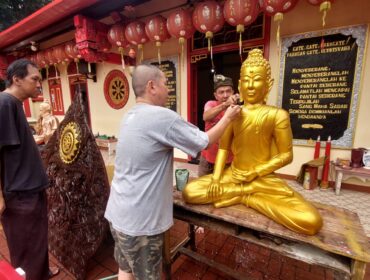 BERSIH-BERSIH: Pengurus klenteng Tri Dharma Sumber Naga Kota Probolinggo, Ervan Sudjuanto, sedang membersihkan patung Budha. (foto: Hafiz Rozani)
