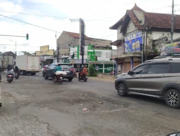 RUSAK: Kondisi jalan rusak di kawasan lampu merah Kecamatan Ajung, Kab. Jember, yang membahayakan para pengguna jalan. (foto: M. Abd. Rozak Mubarak).