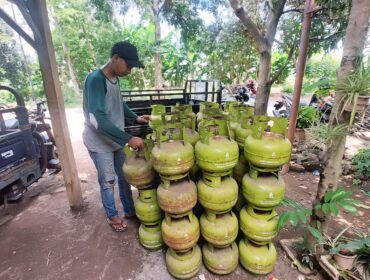 BERKURANG : Pemilik pangkalan di Kota Probolinggo, Muhammad Qosim, sedang merapikan tabung LPG 3 Kg. (foto: Hafiz Rozani).
