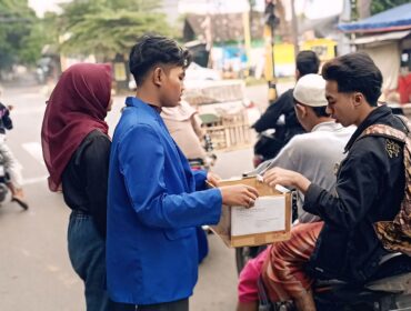 GALANG DANA: Seorang pengguna jalan memberikan bantuan kepada mahasiswa yang menggelar galang dana peduli bencana. (foto: Ali Ya'lu).
