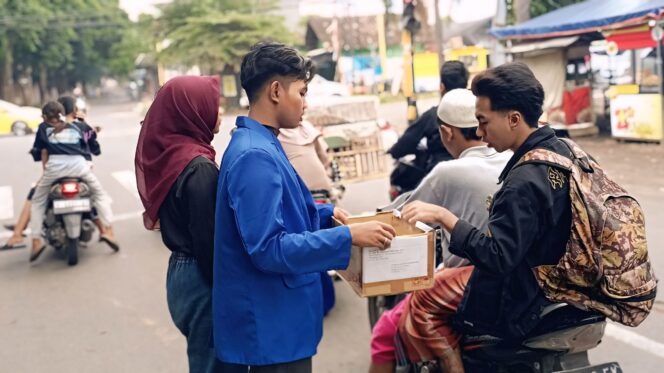 
					GALANG DANA: Seorang pengguna jalan memberikan bantuan kepada mahasiswa yang menggelar galang dana peduli bencana. (foto: Ali Ya'lu).
