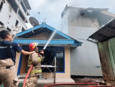 PEMADAMAN: Petugas pemadam kebakaran Kota Probolinggo memadamkan api yang terbakar rumah di Jl. Brigjen Katamso Mayangan. (foto: Hafiz Rozani)