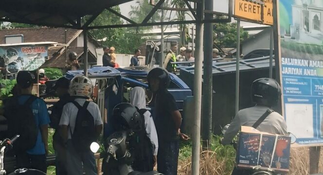 
					LAKA: Truk Dyna warna navi terguling akibat tertabrak KAI Logawa di Kelurahan Baratan, Kecamatan Patrang, Kabupaten Jember. (foto: M. Abd. Rozak Mubarok).
