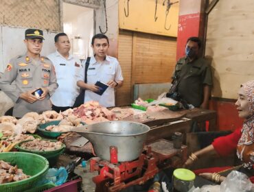 STABILKAN HARGA:  Mandinsareza (memegang buku catatan) saat melakukan sidak harga di Pasar Maron Probolinggo, beberapa waktu lalu. (foto: Ali Ya'lu).