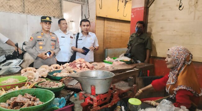 STABILKAN HARGA:  Mandinsareza (memegang buku catatan) saat melakukan sidak harga di Pasar Maron Probolinggo, beberapa waktu lalu. (foto: Ali Ya'lu).