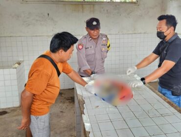 IDENTIFIKASI: Aparat kepolisian sedang mengidentifikasi jasad bayi yang ditemukan di Sungai Bondoyudo Jember. (foto: M. Abd. Rozak Mubarok).
