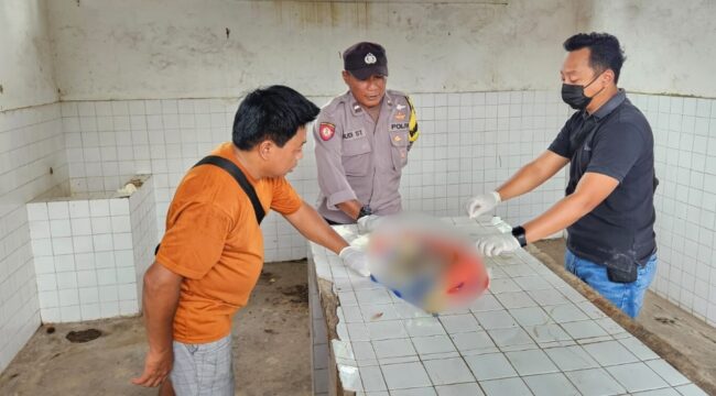 IDENTIFIKASI: Aparat kepolisian sedang mengidentifikasi jasad bayi yang ditemukan di Sungai Bondoyudo Jember. (foto: M. Abd. Rozak Mubarok).
