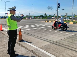 SIAGA: Anggota kepolisan tengah mengatur lalin di akses menuju exit Tol Leces, Probolinggo. (foto: dokumen).
