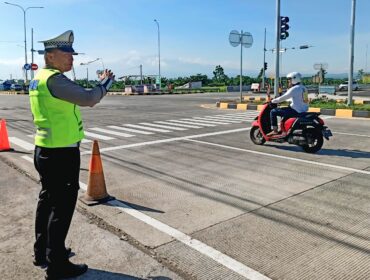 SIAGA: Anggota kepolisan tengah mengatur lalin di akses menuju exit Tol Leces, Probolinggo. (foto: dokumen).
