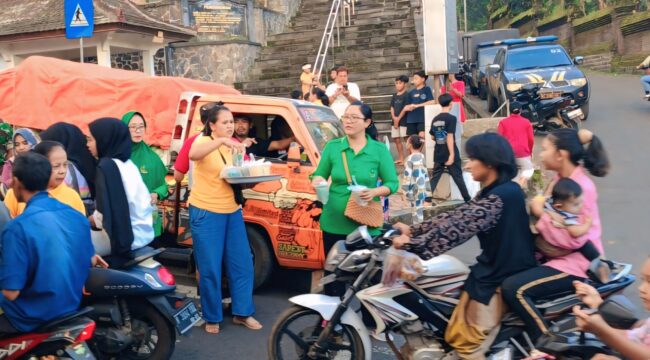 Umat Hindu bagi-bagi takjil di depan Pura Mandhara Giri Semeru Agung, Senduro, Lumajang.