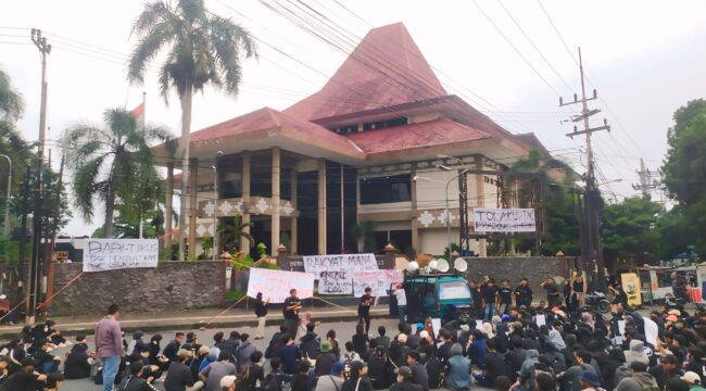 UNJUK RASA: Ratusan mahasiswa berdemo di depan gedung DPRD Jember untuk menolak Revisi UU TNI. (foto: M. Abd. Rozak Mubarok).