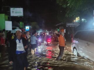 TERHAMBAT: Suasana banjir di depan Mapolsek Krejengan atau Jalan Raya Krejengan - Gading. (foto: Ali Ya'lu).
