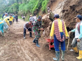 KERJA KERAS: Anggota TNI, Polri dan warga membersihkan material longsor di jalur wisata Bromo via Probolinggo. (foto: Bag. Humas Polres Probolinggo).